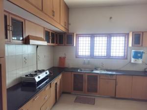 a kitchen with a stove and a sink in it at Serenity Springs in Mysore