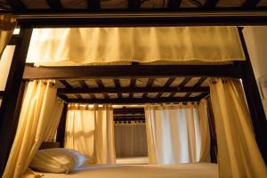 a canopy bed with curtains and pillows in a bedroom at Villa Jogja Tropical in Yogyakarta