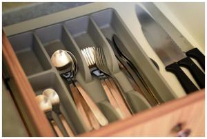 a tray with utensils in a wooden drawer at Color 24 - Złoty Punkt in Stalowa Wola