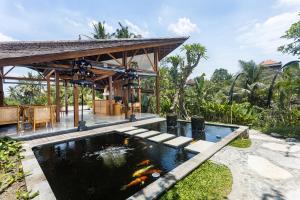 ein Koiteich im Hinterhof eines Hauses in der Unterkunft The Pulu Villas by GenuineHost in Ubud