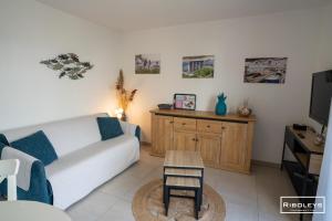 a living room with a couch and a table at Villa T3 à 400m de la plage avec piscine in Vias