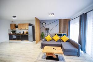 a living room with a gray couch and yellow pillows at MULTIROOMS in Drawsko Pomorskie