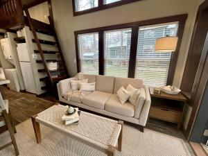 a living room with a couch and a table at Breathtaking Tiny House Settled Between Trees in Tracy City, Tennessee in Tracy City