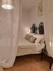 a bedroom with a bed with white curtains at Nel vicolo dei Baci - Casa vacanze al Bacio in Spello
