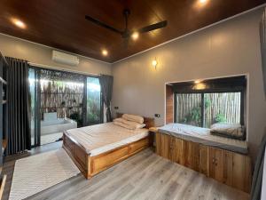 a bedroom with two beds and a large window at Rao Retreat in Ấp Xuân Khai