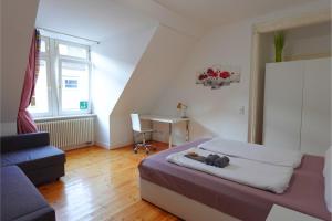 曼海姆Quadrate Hostel Mannheim Z5 Denkmalschutz的一间卧室，配有一张床、一张沙发和一张书桌