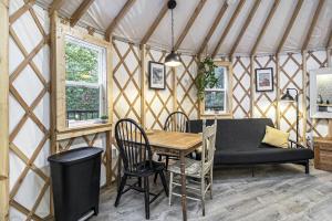 ein Zimmer mit einem Tisch und einer Couch in einer Jurte in der Unterkunft Secluded Glamping Yurt with Scenic Wilderness Views near Sears, Michigan in Sears