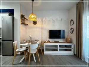 a dining room with a table with chairs and a television at Blanes Playa in Blanes