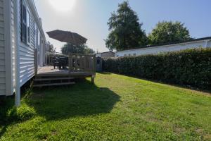 a patio with an umbrella and a table and chairs at Ty Névez in Trégunc
