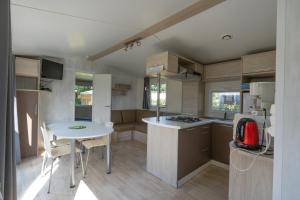 a small kitchen with a white table and a table and chairs at Ty Névez in Trégunc