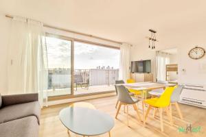 Una sala de estar con una mesa y sillas amarillas. en Résidence Saint-Amand - Proche Paris et Disneyland, en Champigny-sur-Marne