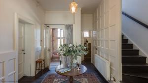 a hallway with a table with a vase of flowers at The Hill in Baldersby