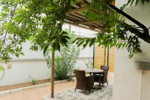 una mesa y sillas en un patio con un árbol en Louise by the Sea, en Grand Baie