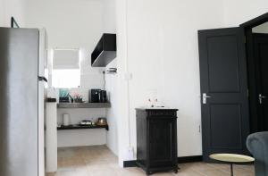 Una sala de estar con una puerta negra y una cocina. en Louise by the Sea, en Grand Baie