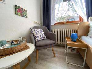a living room with a chair and a table at Stockrosenhuus in Westerland