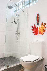 Un baño con inodoro y ducha de cristal. en Louise by the Sea, en Grand Baie