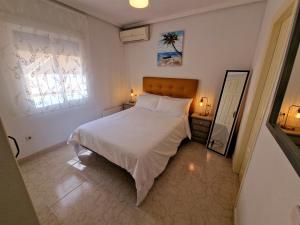 une chambre avec un lit blanc et un miroir dans l'établissement Tranquil Bungalow Retreat, à Ciudad Quesada 26 autres photos