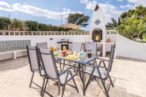une table et des chaises sur une terrasse avec une cheminée dans l'établissement Casa Golondrina, à Moraira