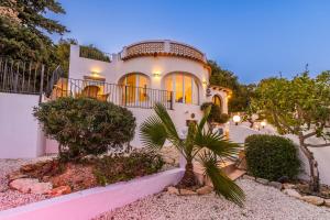 une grande maison blanche avec des arbres devant dans l'établissement Casa Golondrina, à Moraira