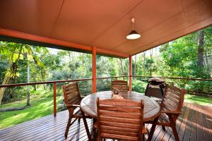 a patio area with chairs and a table at Bushland Cottages and Lodge in Yungaburra