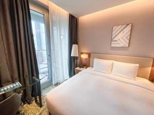 a hotel room with a bed and a large window at Hotel Skypark Central Seoul Pangyo in Seongnam