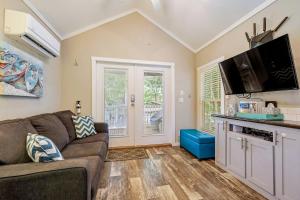 a living room with a couch and a flat screen tv at Riverfront Tiny House with Fire Pit in Seguin, Texas in Seguin