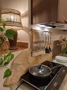 a kitchen with a stove with a pot on it at Nel vicolo dei Baci - Casa vacanze al Bacio in Spello