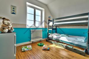 a room with two bunk beds and toys on the floor at LocaLise - M6A - Ty Heol - Maison de vacances à quelques pas du port et des plages - jardin avec terrasse entièrement clos - wifi inclus in Tréffiagat