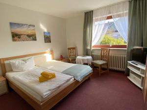 a hotel room with a bed and a television at Stockrosenhuus in Westerland