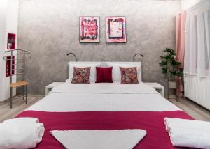 Un dormitorio con una gran cama blanca con almohadas rojas. en MAGIC HOUSE BRASOV, en Brasov