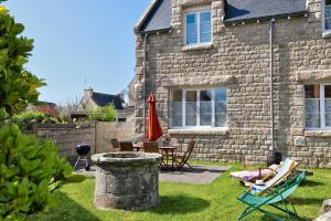a stone house with a patio and a table and chairs at LocaLise - M6A - Ty Heol - Maison de vacances à quelques pas du port et des plages - jardin avec terrasse entièrement clos - wifi inclus in Tréffiagat