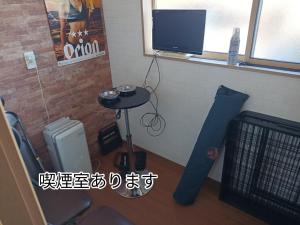a room with a table and a tv and a table with a table at Guest House Ihatov - Vacation STAY 22102v in Takamatsu