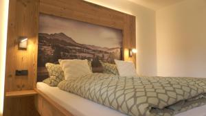 a bedroom with a bed with a painting on the wall at Ferienwohnung Reitemann in Oy-Mittelberg