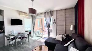 a living room with a couch and a table at Casamea - Vue Mer, Clim & Parking, Proche Plage in Ajaccio