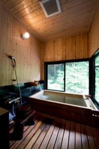 a large bath tub in a room with a window at Onsen Ryokan Yamaki in Nasushiobara