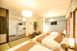 大阪市にあるLarge space FUNHOUSE-TO Big apt 9min-Namba 3min-Umeda USJのベッド2台とキッチン付きのホテルの部屋 +18枚の写真