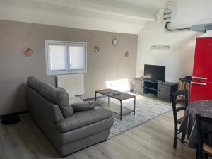 a living room with a couch and a table at La maison du Bas in Naours