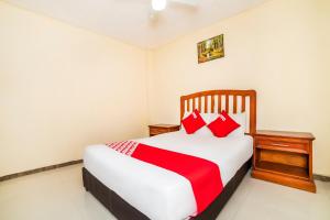 a bedroom with a bed with red pillows at OYO Hotel Bugambilia, San Luis Potosí in San Luis Potosí