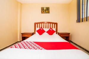 a bedroom with a bed with two red pillows at OYO Hotel Bugambilia, San Luis Potosí in San Luis Potosí