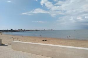 a beach with people swimming in the water at Apartment with sea view parking garden and beach access in La Flotte