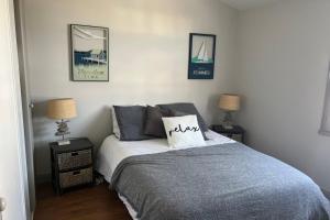 a bedroom with a bed with two night stands and two lamps at Apartment with sea view parking garden and beach access in La Flotte