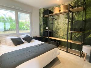 a bedroom with a bed and a large window at Beach house Maison de plage les pieds dans l eau in Plérin +69 photos