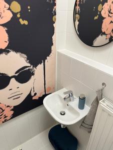 a bathroom with a sink and a picture of a woman at ANER 5 elegantes Neustadt Apartment Abby in Dresden +15 photos