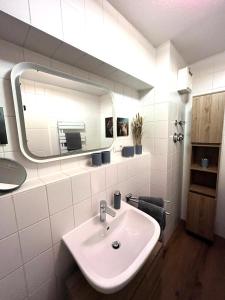 a bathroom with a sink and a mirror at ANER 5 elegantes Neustadt Apartment Abby in Dresden