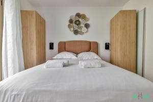 1 cama blanca grande con 2 almohadas blancas. en Résidence Saint-Amand - Proche Paris et Disneyland, en Champigny-sur-Marne