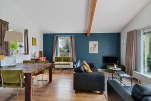a living room with a table and a couch at Huis Mosk heeft grote tuin op het zuiden en nabij meer in Grou