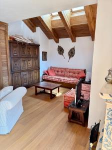 a living room with a red couch and a table at Charme alpino e modernità-Appartamento ristrutturato a due passi dal centro in Cortina dʼAmpezzo