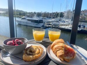 a table with two plates of pastries and a bowl of fruit at Stunning Marina Apartment in Portishead