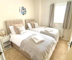 a bedroom with two beds with towels on them at Stunning Marina Apartment in Portishead