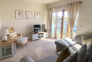 a living room with a couch and a tv at Stunning Marina Apartment in Portishead